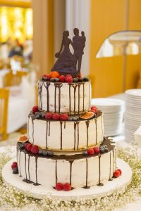 Hochzeitstorte mit Früchten und Brautpaar aus Schokolade