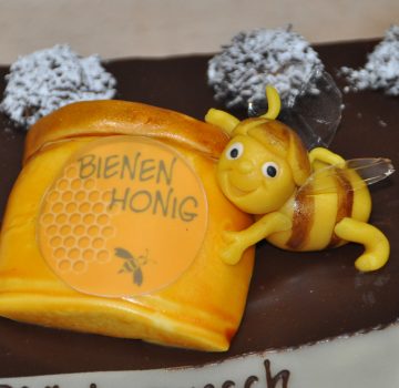 Ausschnitt einer Geburtstagstorte; Biene am Honigglas