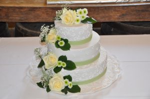 Hochzeitstorte mit echten Blumen und weißen Elementen